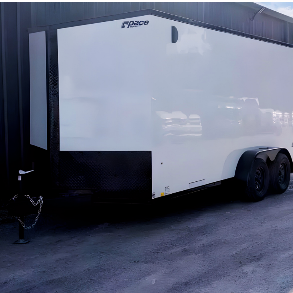 A 2026 PACE 7X16 JOURNEY SE Flat Top trailer with white exterior, 12" extra height, and ramp door is parked beside a building on gravel.