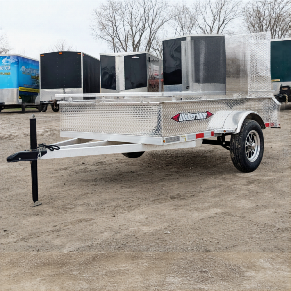 2025 WEBERLANE 5X8 Aluminum Utility trailer with diamond plate surface and single axle, parked on gravel near other trailers and enclosed units.